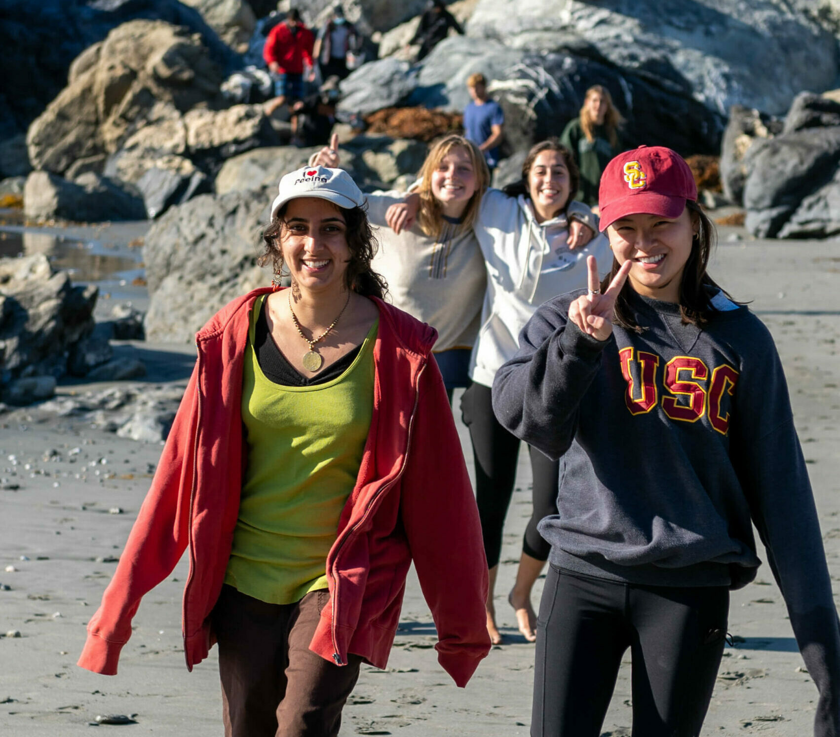 A group of smiling Environmental Studies students walks onto the beach on Catalina Island