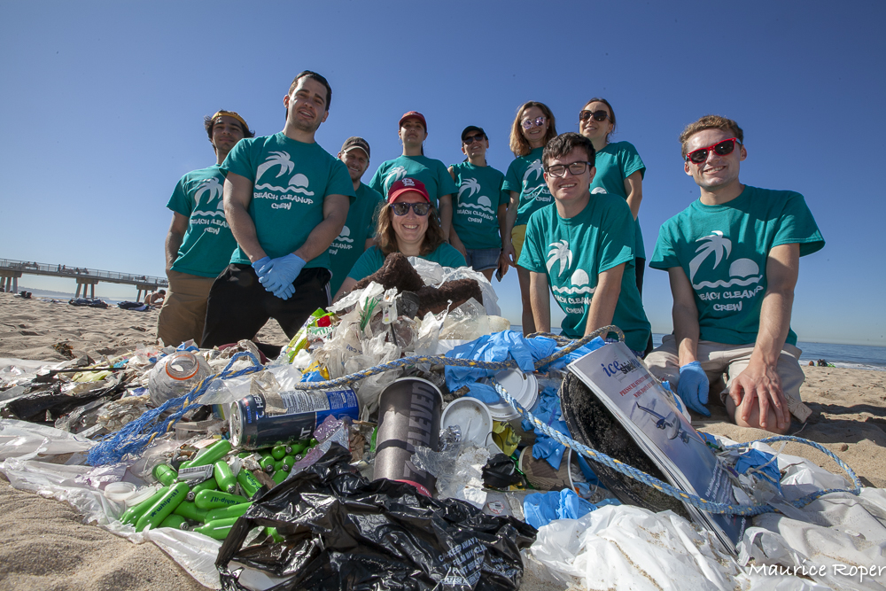 Wrigley Institute faculty affiliate Megan Fieser poses with a group of students behind the trash they collected during a beach cleanup
