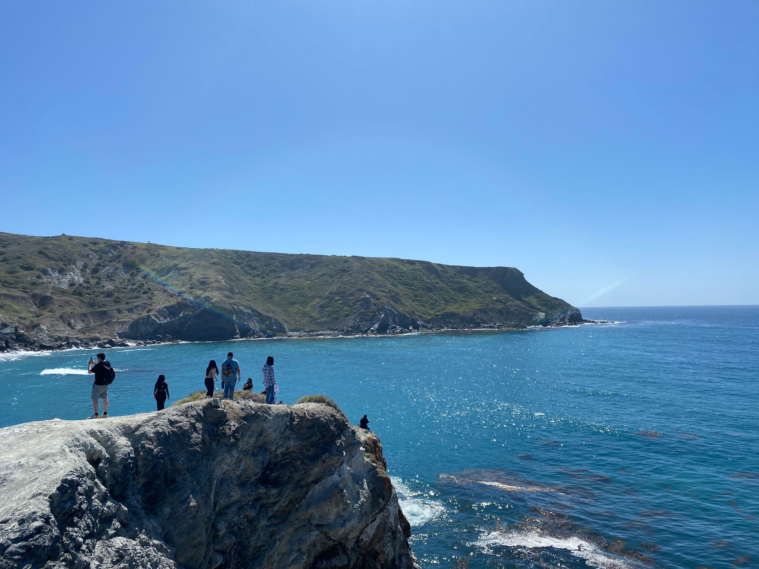 spring break students stand on a clifftop overlooking Big Fisherman Cove and the San Pedro Channel