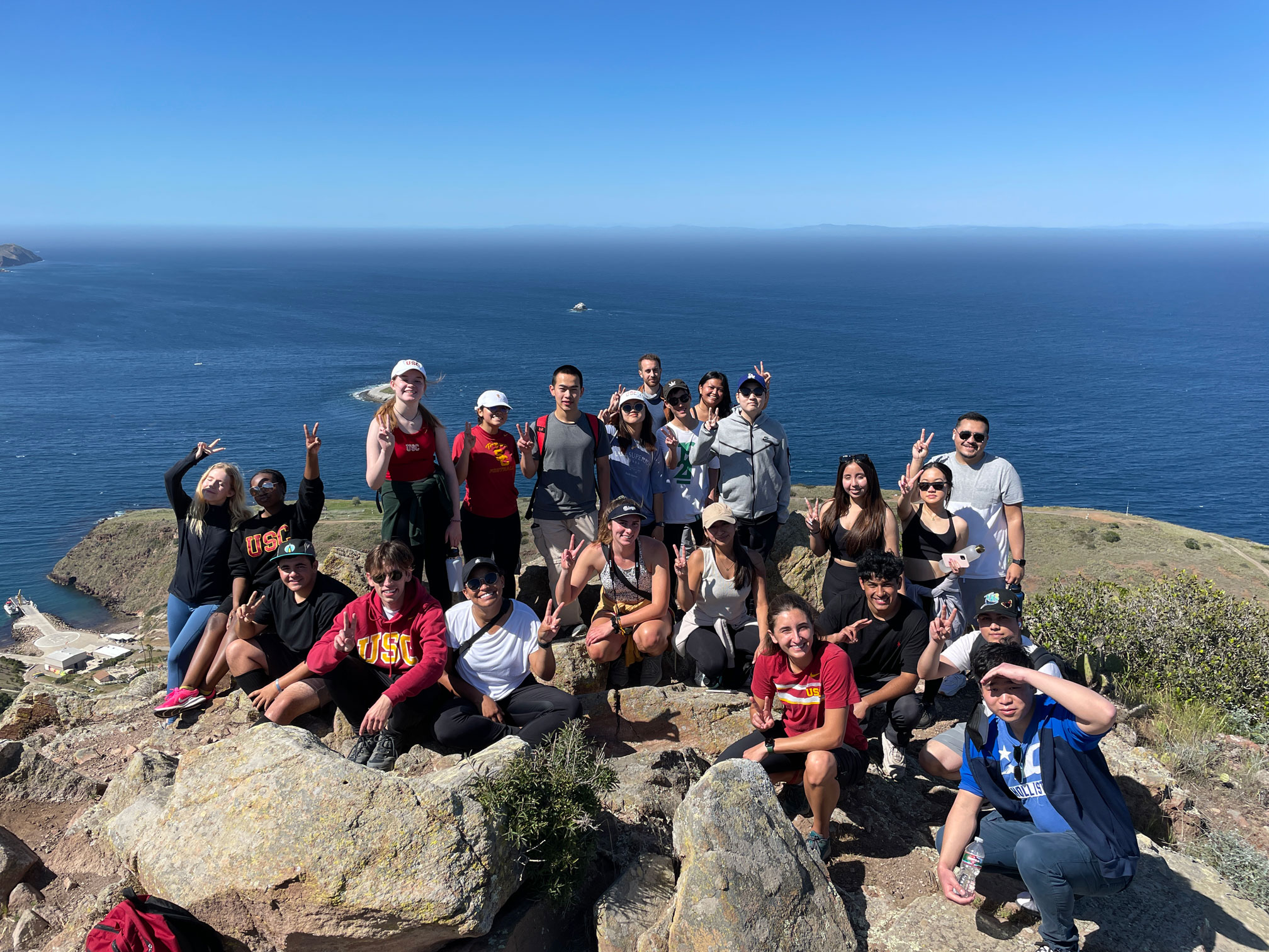 Students pose for a group photo after hiking to the top of a cliff on Catalina Island