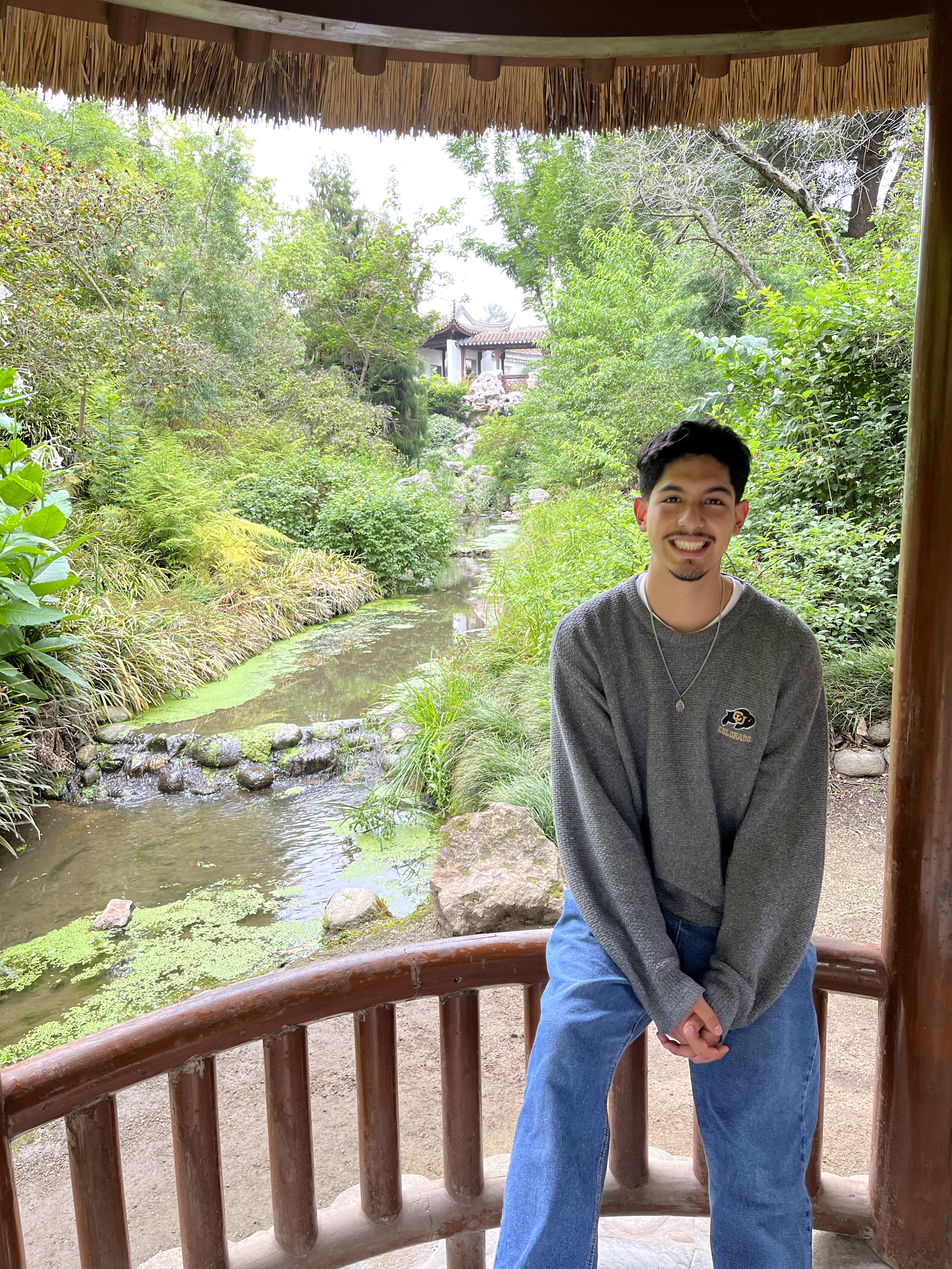 person smiles in front of the Japanese garden at The Huntington Library, Art Museum, and Botanical Gardens in Pasadena, CA.